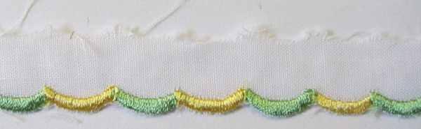 Baumwollspitze weiß, mit gelb/grün gestickter Bogenkante 15 mm